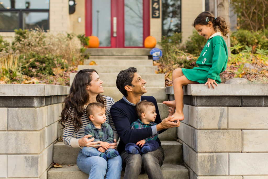 Family laughing together in front of their home in the Indianapolis area.